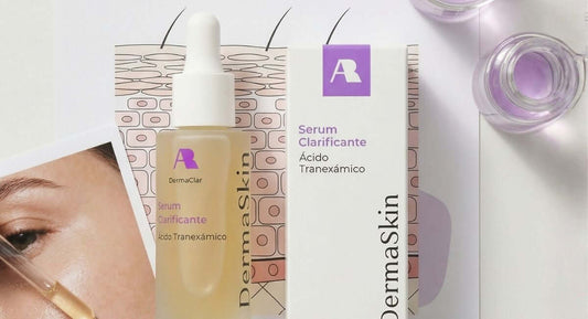 Frasco de serum clarificante con ácido tranexámico y su packaging, ideal para tratar manchas en la piel.
